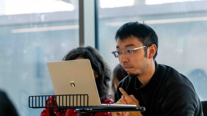 Man looks at laptop.