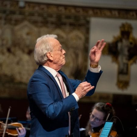 Howard Shelly conducting an orchestra.