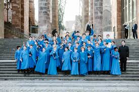 A choir wearing blue smocks